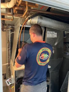 Technician working on HVAC equipment in a mechanical room.